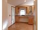 Office area with vaulted ceilings, built-in desk, cabinets, and wood floors at 26225 Troon Ave, Mount Plymouth, FL 32776