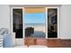 Partial ocean view with sliding glass doors, furniture on patio, and hardwood floors at 2855 S Atlantic Ave # 303, Daytona Beach Shores, FL 32118