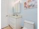 Stylish bathroom features a white vanity with a marble countertop, an over-the-sink mirror, and light blue walls at 2855 S Atlantic Ave # 303, Daytona Beach Shores, FL 32118