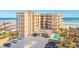 Beautiful tan condo building featuring ocean views, a pool, parking, and manicured landscaping at 2855 S Atlantic Ave # 303, Daytona Beach Shores, FL 32118