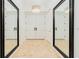 Inviting hallway with double doors, tile flooring and framed mirrors at 2855 S Atlantic Ave # 303, Daytona Beach Shores, FL 32118