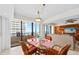 Charming dining area with wicker chairs, a modern chandelier, and sliding door to balcony at 2900 N Atlantic Ave # 2003, Daytona Beach, FL 32118