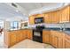 Bright kitchen featuring wooden cabinetry, granite countertops, and modern appliances with a view of the ocean at 2900 N Atlantic Ave # 2003, Daytona Beach, FL 32118