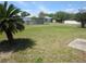 View of a large backyard with a palm tree near a wooden fence and the home's exterior at 2936 Lantern Dr, South Daytona, FL 32119
