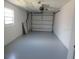 Spacious garage with a window, a white garage door and newly painted gray floors at 2936 Lantern Dr, South Daytona, FL 32119