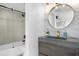 Modern bathroom featuring a stone vanity, a framed mirror, and a glass-enclosed shower and tub combination at 2947 S Atlantic Ave # 201, Daytona Beach Shores, FL 32118