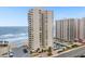 An aerial view showcases the beachfront condos, a swimming pool, and beautiful surroundings at 2947 S Atlantic Ave # 201, Daytona Beach Shores, FL 32118