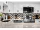 Modern kitchen featuring stainless steel appliances, white cabinetry, stone countertops, and stylish backsplash at 2947 S Atlantic Ave # 201, Daytona Beach Shores, FL 32118