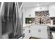 Bright kitchen features stainless steel appliances, white cabinets, granite countertops and decorative backsplash at 2947 S Atlantic Ave # 201, Daytona Beach Shores, FL 32118