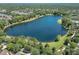 Beautiful aerial view of the community lake surrounded by lush trees and neighborhood homes at 302 Lamberton Ln, Deland, FL 32724