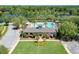 Aerial view of the community clubhouse with a pool, surrounded by palm trees and meticulously kept grounds at 302 Lamberton Ln, Deland, FL 32724