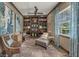 Comfortable den featuring built-in bookshelves, a plush chaise lounge, and ample natural light from the window at 302 Lamberton Ln, Deland, FL 32724