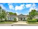 Inviting single-story home featuring a well-maintained lawn and a covered entrance with elegant columns at 302 Lamberton Ln, Deland, FL 32724