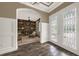 Welcoming foyer with glass-paneled doors, wainscoting, and an archway leading to a cozy den at 302 Lamberton Ln, Deland, FL 32724