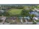 Aerial view of a residential community highlighting a verdant pond surrounded by homes and lush trees at 303 E Floral Ave, Eustis, FL 32726