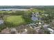 Aerial view of the neighborhood, with homes near lush trees, a green pond, and a serene lake at 303 E Floral Ave, Eustis, FL 32726