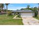 Charming single-story home featuring an attached two-car garage, lush lawn and mature landscaping at 303 E Floral Ave, Eustis, FL 32726