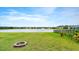 Spacious backyard with a fire pit, lush green grass, and a pond view at 3120 Areca Ave, New Smyrna Beach, FL 32168