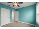 A teal bedroom with wood-look flooring, two doors, and a ceiling fan at 3120 Areca Ave, New Smyrna Beach, FL 32168