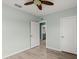 Bedroom with ceiling fan, light blue walls, and wood-look flooring with ensuite bathroom at 3120 Areca Ave, New Smyrna Beach, FL 32168