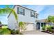 Side view of a charming two-story home with a two car garage and lush landscaping at 3120 Areca Ave, New Smyrna Beach, FL 32168