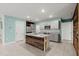The open kitchen offers stainless appliances, gray cabinets and an eat-in island with wood accents at 3120 Areca Ave, New Smyrna Beach, FL 32168