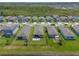 Aerial view of houses in a neighborhood near a lake with landscaped lawns at 3128 Crab Trap Dr, New Smyrna Beach, FL 32168