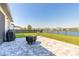 Landscaped backyard overlooking the lake, features a paved patio area with grill and swing set at 3128 Crab Trap Dr, New Smyrna Beach, FL 32168