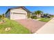 Single-story home featuring a two-car garage, brick driveway and well manicured lawn at 3128 Crab Trap Dr, New Smyrna Beach, FL 32168