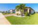 Well-maintained front yard with palm trees, shrubs, and a brick driveway leading to a two-car garage at 3128 Crab Trap Dr, New Smyrna Beach, FL 32168
