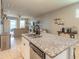 Open kitchen with granite island, stainless steel dishwasher, and views into the living and dining area at 3128 Crab Trap Dr, New Smyrna Beach, FL 32168
