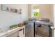 Bright laundry room with modern washer and dryer, decor, and a window bringing in natural light at 3128 Crab Trap Dr, New Smyrna Beach, FL 32168