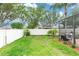 Spacious backyard featuring a white fence, lush green grass, and a screened-in patio, perfect for outdoor relaxation at 316 Oak Springs Dr, Debary, FL 32713