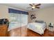 Bright bedroom features hardwood floors, ceiling fan, and sliding glass door to the pool at 316 Oak Springs Dr, Debary, FL 32713