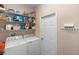 A simple laundry room is equipped with a washer, dryer, and ample storage shelving at 316 Oak Springs Dr, Debary, FL 32713