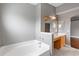 Primary bathroom with large tub, tile floor, and double sinks with wood cabinets at 3267 Wild Pepper Ct, Deltona, FL 32725