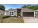 Charming single-story home featuring a well-maintained lawn and an attached two-car garage, with small palms enhancing curb appeal at 3267 Wild Pepper Ct, Deltona, FL 32725