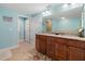 Well-lit bathroom featuring double sinks, granite countertops, and a separate toilet room at 3799 S Atlantic Ave # 601, Daytona Beach, FL 32118