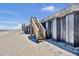 Beach access point featuring wooden stairs leading up to a concrete structure on a sunny day at 4363 S Atlantic Ave, Ponce Inlet, FL 32127
