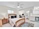 Bright bedroom featuring a ceiling fan, desk, and access to an ensuite bathroom at 4363 S Atlantic Ave, Ponce Inlet, FL 32127