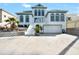 Stunning exterior of a two-story home featuring a two-car garage, complemented by lush tropical landscaping at 4363 S Atlantic Ave, Ponce Inlet, FL 32127