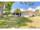 View of the backyard featuring a screened patio and mature trees with a lush lawn at 4589 Alder Dr, Port Orange, FL 32127