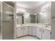 Bright bathroom featuring a double vanity, large mirrors, and a glass-enclosed shower at 4589 Alder Dr, Port Orange, FL 32127