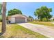 Spacious driveway leading to a well-kept home with a manicured lawn and mature trees at 4589 Alder Dr, Port Orange, FL 32127