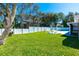 Lush backyard with a well-maintained lawn, white picket fence, and outdoor dining area at 4745 Dixie Dr, Ponce Inlet, FL 32127