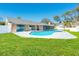Serene backyard features a sparkling pool, perfect for outdoor entertaining with an enclosed lanai and lush lawn at 4745 Dixie Dr, Ponce Inlet, FL 32127
