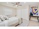 Bright bedroom features a ceiling fan, wood-look tile floor, and a decorative painting at 4745 Dixie Dr, Ponce Inlet, FL 32127