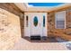 Home's front door features classic white design with brick surround and walkway at 4745 Dixie Dr, Ponce Inlet, FL 32127