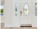 Elegant white front door with decorative glass panels, offering a welcoming entrance and plenty of natural light at 4745 Dixie Dr, Ponce Inlet, FL 32127