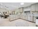 Bright and airy kitchen open to the dining area, featuring grey cabinets and a skylight at 4745 Dixie Dr, Ponce Inlet, FL 32127